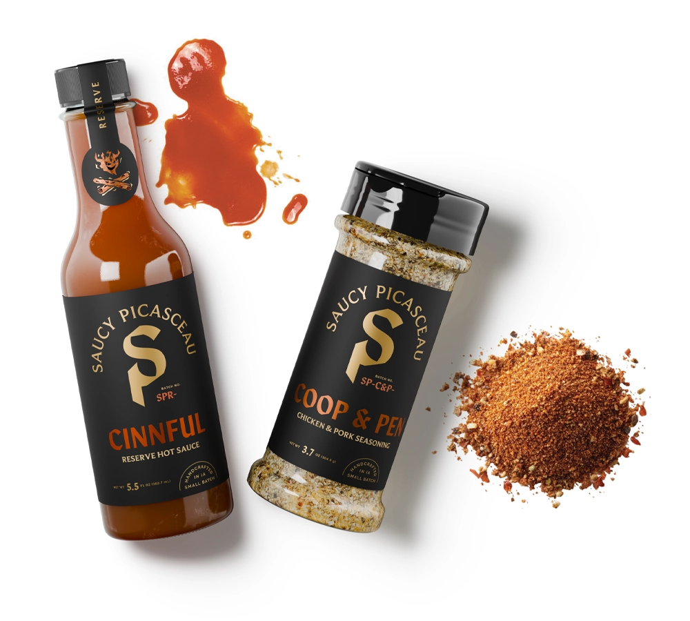 Saucy Picasceau Cinnful Reserve Iowa hot sauce and Coop & Pen seasoning with sauce splash